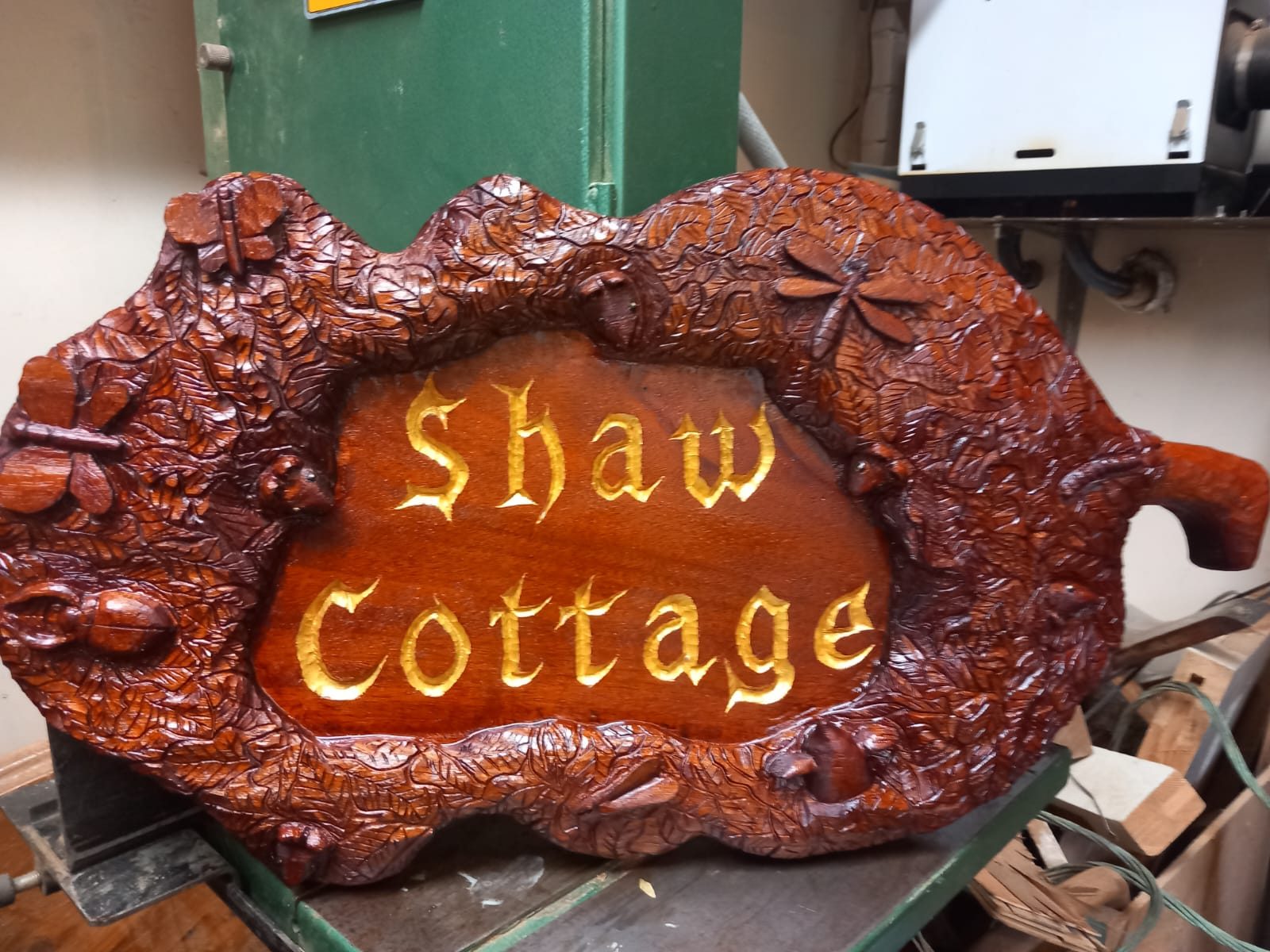 Carved house sign reading Shaw Cottage